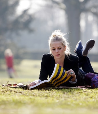 Vrouw leest boek in park Den Haag Marketing